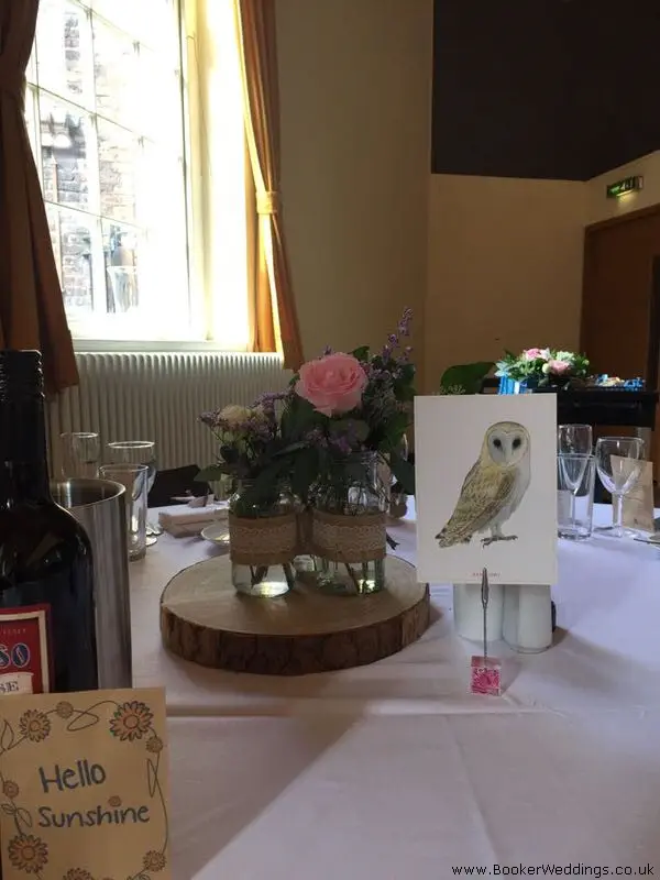 Table Centrepiece of Roses In Jars on Wood Slices
