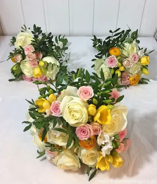 Bride and bridesmaid hand-tied spring bouquets including roses, freesia, narcisis and ranunculus