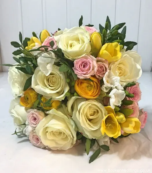 Bride hand-tied bouquet of spring flowers in white, yellow and pink
