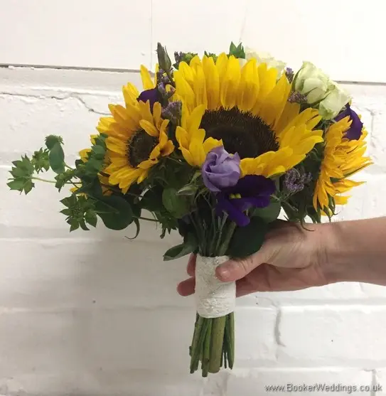 Bridesmaid handtied bouquet with sunflowers, yellow gerberas, white spray roses, purple limoneum and purple lissianthus side view