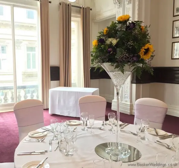 Tall yellow, white and purple sunflower martini glass table arrangements on mirror plates at Doubletree by Hilton Liverpool