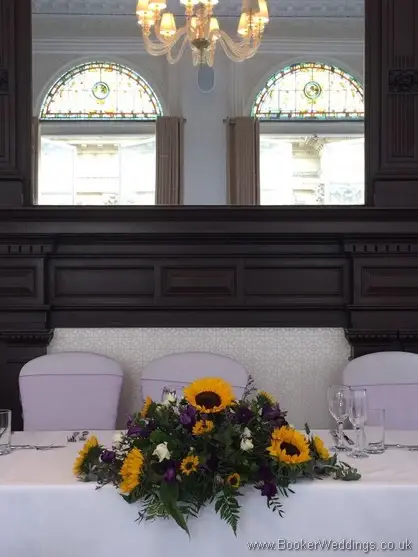 Top Table Arrangement of Sunflowers, yellow gerberas, white spray roses, purple lissianthus at Doubletree by Hilton Liverpool
