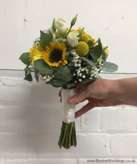 Bridesmaid handtied bouquet in yellow and creams with yellow sunflowers, craspedia, roses, gypsy grass, lissanthus and grey eucalyptus side view
