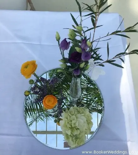 Trio of jars and mirror plate with just picked yellow and purple flowers